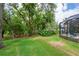 Backyard view with a covered pool deck and lush landscaping provides privacy at 2712 Spring Meadow Dr, Plant City, FL 33566
