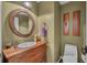This bathroom offers a wooden vanity and circular mirror at 2712 Spring Meadow Dr, Plant City, FL 33566
