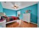 This cozy bedroom is painted blue, featuring wood floors and a bright, colorful bedspread at 2712 Spring Meadow Dr, Plant City, FL 33566