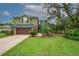 Charming two-story home with a lush, landscaped front yard featuring a lovely garden and a two-car garage at 2712 Spring Meadow Dr, Plant City, FL 33566