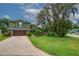 Charming two-story home with a lush, landscaped front yard, two-car garage and mature trees at 2712 Spring Meadow Dr, Plant City, FL 33566