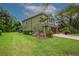 View of large backyard and the side of a two-story home with a two-car garage and manicured lawn at 2712 Spring Meadow Dr, Plant City, FL 33566