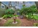 Landscaped yard with a decorative fountain, cozy bench, and lush greenery including mature trees at 2712 Spring Meadow Dr, Plant City, FL 33566