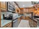 Gourmet kitchen boasting stainless steel appliances, granite counters, custom cabinets and ample cooking space at 2712 Spring Meadow Dr, Plant City, FL 33566