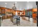 Expansive kitchen with custom wood cabinetry, oversized island, granite countertops, and pool table access at 2712 Spring Meadow Dr, Plant City, FL 33566
