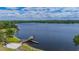 Scenic view of a lake with a pier and surrounding lush greenery on a cloudy day at 2712 Spring Meadow Dr, Plant City, FL 33566