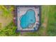 Aerial shot of freeform screened pool area with an attached spa and lounge chairs at 2712 Spring Meadow Dr, Plant City, FL 33566