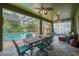 A covered porch holds a dining table next to the pool and lanai at 2712 Spring Meadow Dr, Plant City, FL 33566