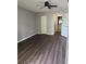 Clean bedroom featuring wood-look floors, neutral walls, ceiling fan, and an ensuite bathroom at 2753 Countryside Blvd # 107, Clearwater, FL 33761