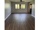 Spacious living room with wood-look flooring, natural light, and a ceiling fan at 2753 Countryside Blvd # 107, Clearwater, FL 33761