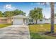 Charming single-story home featuring a well-manicured lawn, attached garage, and inviting front entrance at 2858 State Road 590, Clearwater, FL 33759