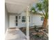 Inviting front porch with tropical landscaping and a welcoming doormat at 2858 State Road 590, Clearwater, FL 33759