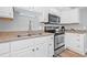Well-equipped kitchen featuring stainless steel appliances, white cabinets and ample counter space at 2858 State Road 590, Clearwater, FL 33759