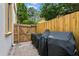 The brick-paved backyard has a wooden fence and features three barbecues ready to be used at 2936 W Knights Ave # A, Tampa, FL 33611