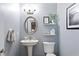 Elegant powder room features a pedestal sink, oval mirror, and grey walls at 2936 W Knights Ave # A, Tampa, FL 33611