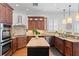 Spacious kitchen with stainless steel appliances, granite countertops, wooden cabinets, a central island, and hardwood floors at 2936 W Knights Ave # A, Tampa, FL 33611