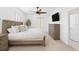 Bright main bedroom with neutral walls, plush carpet, plantation shutters, ceiling fan, and TV at 2936 W Knights Ave # A, Tampa, FL 33611
