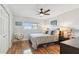 A bright bedroom with wood floors, ceiling fan, large window with view, and simple furniture set at 2960 59Th S St # 614, Gulfport, FL 33707