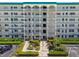 The front of a condo building, with manicured landscaping, sidewalks, and an American flag at 2960 59Th S St # 614, Gulfport, FL 33707
