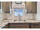 Stylish kitchen features a modern sink, granite countertops, and window with a view at 2960 59Th S St # 614, Gulfport, FL 33707