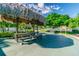 Community picnic area with a thatched roof gazebo, wooden picnic table and barbecue grill for outdoor dining at 2960 59Th S St # 614, Gulfport, FL 33707