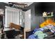 Untidy bedroom with dark walls, blinds, and an assortment of personal belongings, featuring a mounted flat-screen television at 3008 Jackson N St, St Petersburg, FL 33704