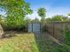 View of a fenced backyard with mature landscaping, storage shed, and wood at 3305 10Th N Ave, St Petersburg, FL 33713