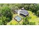 Expansive elevated home featuring a screened pool, lush landscaping, and detached carport at 35031 Shale St, Webster, FL 33597