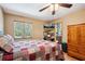 Bedroom with hardwood floors, ceiling fan, TV, and a window with natural light at 35031 Shale St, Webster, FL 33597