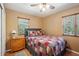 Inviting bedroom featuring a comfy bed, two windows, and a wooden dresser at 35031 Shale St, Webster, FL 33597