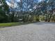 Gravel driveway leading to property with mature trees and a charming water feature at 35031 Shale St, Webster, FL 33597