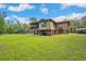 Exterior view of house featuring a large manicured yard, screened-in pool, and plenty of parking at 35031 Shale St, Webster, FL 33597