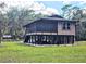 Unique raised home design with screened porch and ample outdoor seating area at 35031 Shale St, Webster, FL 33597