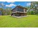 Exterior view of house featuring a large yard, screened-in pool, plenty of parking, and screened-in porch at 35031 Shale St, Webster, FL 33597