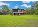 Exterior view of house featuring a lush lawn, screened-in pool, and plenty of parking space at 35031 Shale St, Webster, FL 33597
