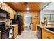 Cozy kitchen featuring wood cabinets, black appliances, tile countertops and flooring at 35031 Shale St, Webster, FL 33597