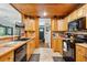 Kitchen showcasing wood cabinetry, black appliances, and direct access to entry at 35031 Shale St, Webster, FL 33597