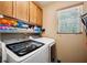 Laundry room with front load washer and dryer, storage cabinets, and natural light at 35031 Shale St, Webster, FL 33597