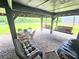 Relaxing under deck with porch swings, chairs, table, and a view of the well manicured lawn at 35031 Shale St, Webster, FL 33597