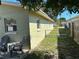 Side view of home with window, outdoor chairs and table, grass, and fence in yard at 3827 15Th N Ave, St Petersburg, FL 33713