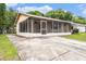 A view of the exterior side of the single-story house, with a screened-in porch and concrete driveway at 4312 Las Vegas Dr, New Port Richey, FL 34653