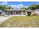 Charming single-story home featuring stone accents, a screened-in front porch, and a well-maintained lawn at 4312 Las Vegas Dr, New Port Richey, FL 34653