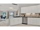 Bright kitchen featuring white cabinets, black countertops, stainless steel appliances, and tile flooring at 4333 Bayside Village Dr # 110, Tampa, FL 33615