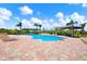 Community pool with surrounding brick pavers, lounge chairs, and tropical landscaping at 4333 Bayside Village Dr # 110, Tampa, FL 33615