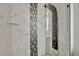 Close-up of a spa-like shower with marble tile, mosaic accents, and a modern rainfall shower panel at 4333 Bayside Village Dr # 110, Tampa, FL 33615