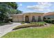 Charming single-story home featuring an arched entryway, two-car garage, and manicured front yard at 4518 W Woodmere Rd, Tampa, FL 33609