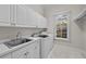 Well-lit laundry room equipped with ample counter space, cabinetry, and modern washer and dryer at 4518 W Woodmere Rd, Tampa, FL 33609