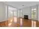 Bright living room with hardwood floors, a fireplace, columns, and large windows with elegant plantation shutters at 4518 W Woodmere Rd, Tampa, FL 33609