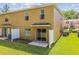 Back of tan townhome showing patio and view to the lawn at 4528 Winding River Way, Land O Lakes, FL 34639