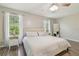 Bright bedroom with a ceiling fan, dark wood floors, and white walls at 4528 Winding River Way, Land O Lakes, FL 34639
